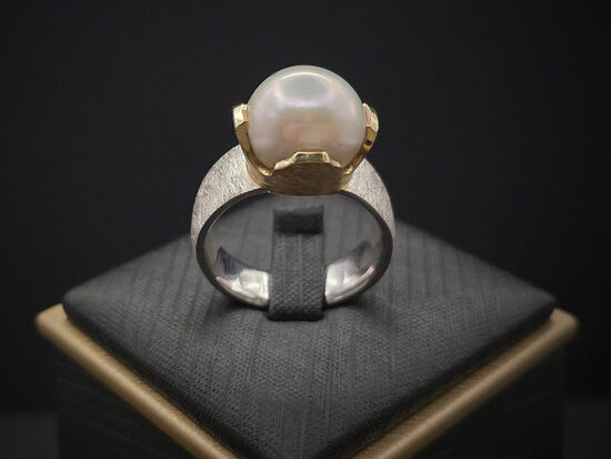 MĒNESS BĒRNS. Sudraba gredzens ar pērli un apzeltītiem elementiem, Ø18,7